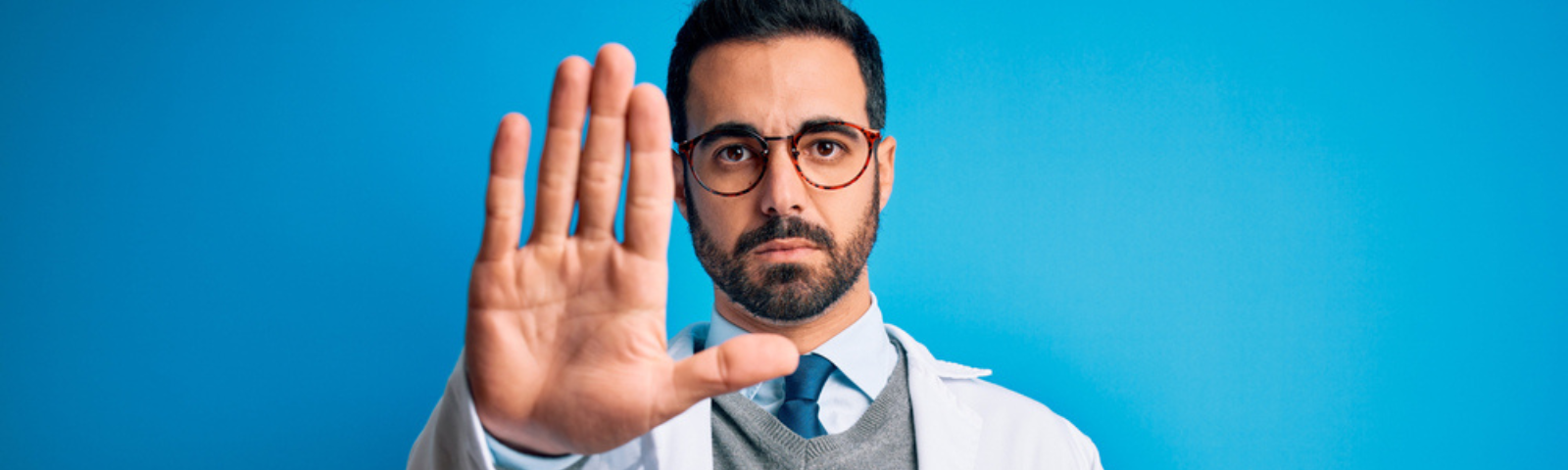 médico hombre con mano en señal de “pare”